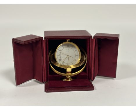 A Swiss contemporary brass desk clock, inscribed "Jean Roulet Le Locle", with star sign aperture, with Arabic Roman hour nume