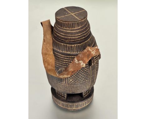 A Somali carved wood milk flask with chip wood decoration of mallet shape raised on four carved supports and circular base wi