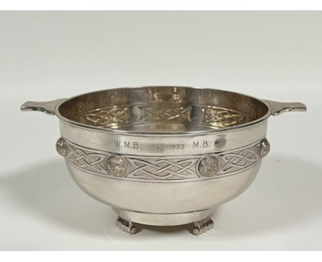 A large silver plated celtic-revival style bowl in the form of a quaich, decorated with celtic knot and raised on scroll supp