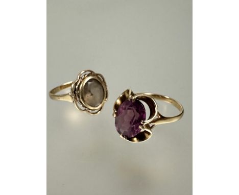 A 9ct gold 1970s dress ring set oval faceted amethyst in four claw scroll settings O 3.31g and a yellow metal dress ring set 