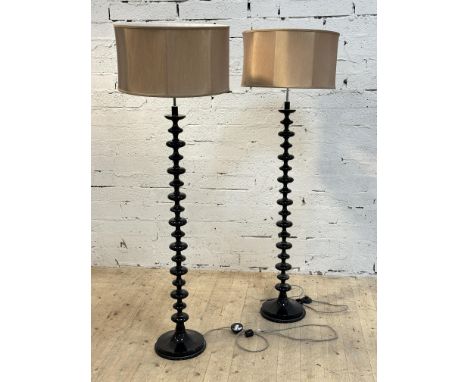 A pair of contemporary black acrylic 1960s style bobbin column floor lamps on circular weighted bases, complete with gold dru