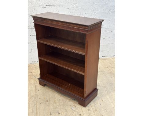 A reproduction mahogany inlaid upright open bookcase with moulded frieze, fitted two adjustable shelves, raised on bracket fe