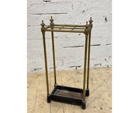 An Edwardian brass six division stick and umbrella stand with urn finials, on weighted cast iron base. H x 64cm, L x 30cm, D 