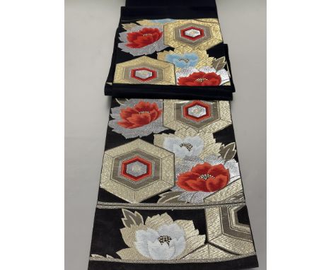 A vintage Japanese Obi belt with black ground worked with gilt, silvered, and coloured threads with stylized chrysanthemum an