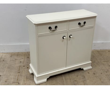 A cream painted hardwood hall cabinet with moulded edge above two short drawers and two panel doors enclosing a shelved inter