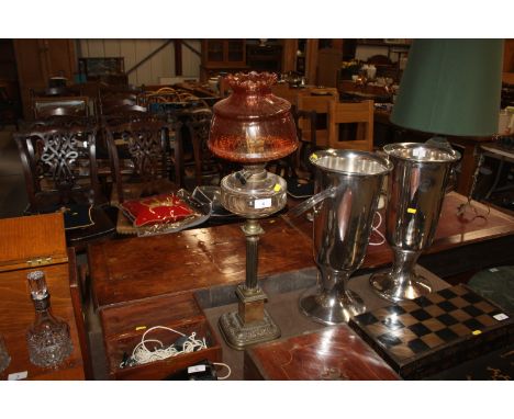 A Victorian table oil lamp supported on a brass Corinthian column and onyx base, with ruby tinted shade 