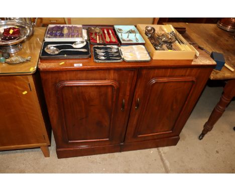 A mahogany two door cabinet fitted sliding trays and shelf 