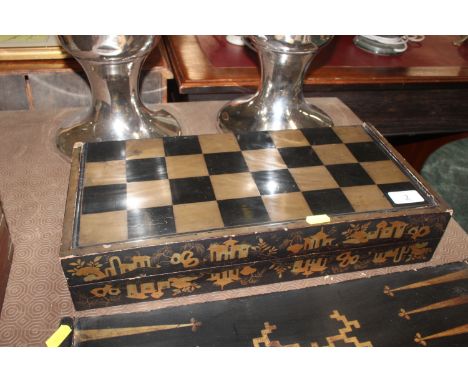 A 19th Century Chinese lacquered folding backgammon and chess board, complete with two dice shakers