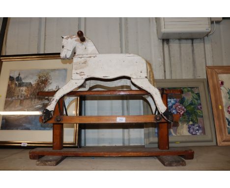 A small painted wooden rocking horse on stand 