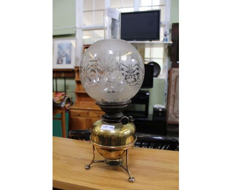 A brass based oil lamp, with etched globular shade 