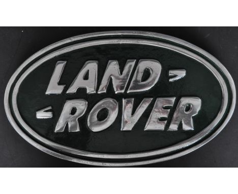 A 20th Century vintage style aluminium Land Rover plaque/badge car logo. The logo of oval form with silver font and green bac