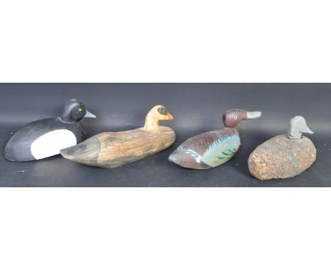 A collection of four vintage folk art decoy ducks comprising a cork example with carved wooden head, elongated carved example