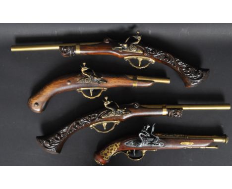 A collection of four vintage decorative 18th century style flint lock pistols. The pistols having decorative handles with fla