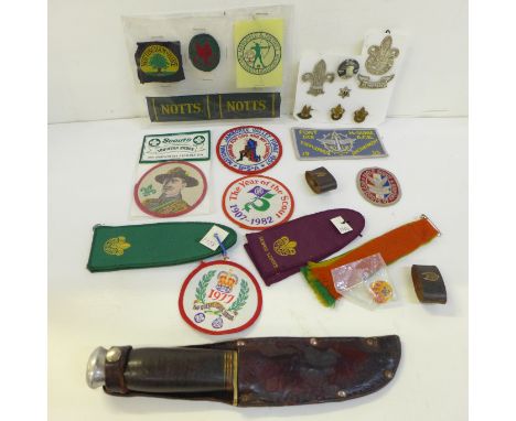 A collection of Scout badges, cloth and metal, two leather woggles and a Scout knife and scabbard, mid 20th Century 