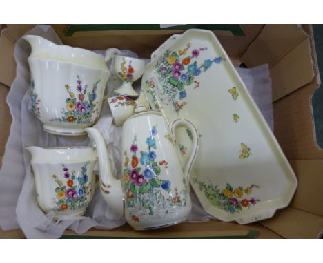 A Crown Staffordshire Hollyhocks design tea service, yellow background and white background, three jugs, coffee pot, two dinn
