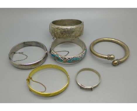 Four silver bangles including one child's, 100g, a white metal bangle and a '9ct gold metal core' bangle 