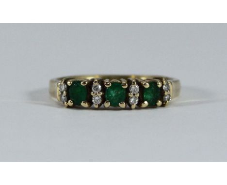 A 14K gold, emerald and diamond ring, claw-set, three round faceted emeralds, eight small diamonds, 3.10g 