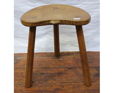 A Robert 'Mouseman' Thompson of Kilburn oak three-legged calf stool, the dished, kidney shaped seat with signature carved mou