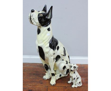 A large ceramic figure of a black and white Great Dane, together with a small ceramic figure of a dalmatian puppy, tallest me