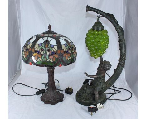 A Tiffany style multi-coloured lamp together with a lamp in the shape of a fruiting vine with a child reaching for a bunch of