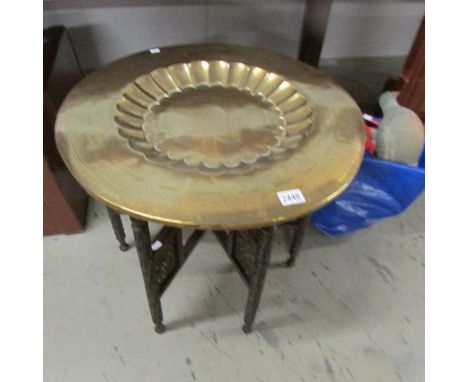 A brass topped table with folding base.