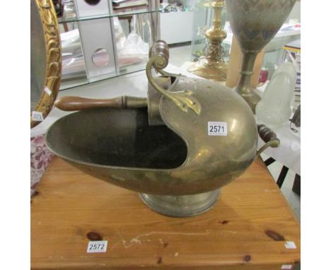 A brass 'helmet' coal scuttle with coal scoop.