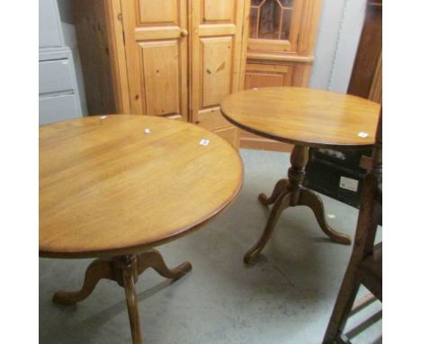 A pair of oak tripod tables.