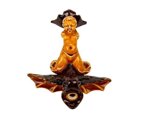 Rich, earth-tone majolica glazed finish.An allegorical study modeled as a young Triton (mermaid) boy on a stylized wing sea c