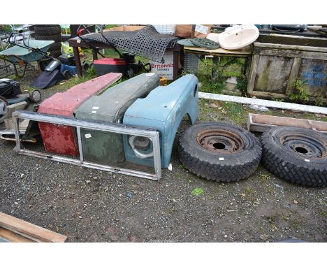 Three offside Land Rover mud wings plus a quantity of panels and a front windscreen.