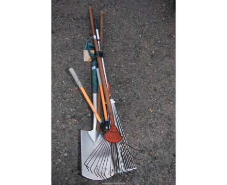 Garden tools including a stainless steel spade, lopper and garden rakes,