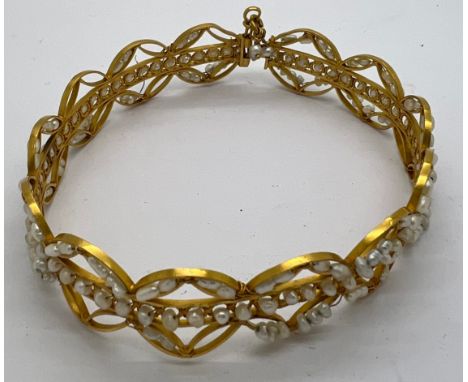 A yellow metal bangle with seed pearl decoration. Tests as 22ct gold. 19gm total weight.Condition ReportSome pearls missing.
