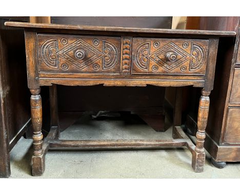 An oak side table with 2 drawers to front with carving. 114 w x 49 d x 84cm h.Condition ReportWatermarks to top.