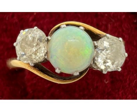 An 18ct gold ring set with central opal and diamonds to either side. Size R, 4.5gm.Condition ReportGood condition.