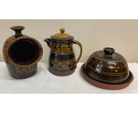 Three pieces of slipware pottery to include salt pig, coffee/ teapot and lidded dish. Salt pig 19cm h. Base diameter 20.5cm.C