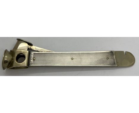 A hallmarked silver cigar cutter with engine turned decoration, Birmingham 1959, maker possibly William Manton Ltd. 15cm l.