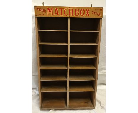 Matchbox Toys wall mounted display shelf, pine cased, 6 height with Matchbox advertising panel. 12 section. 76 h x 44 w x 15c