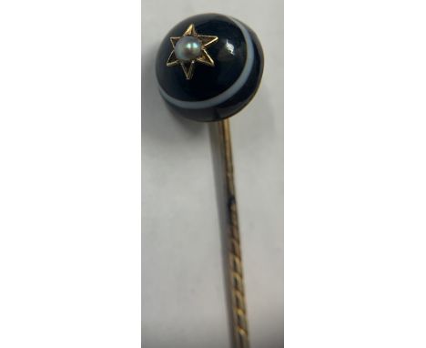 Banded agate and seed pearl mourning stick pin set on yellow metal.