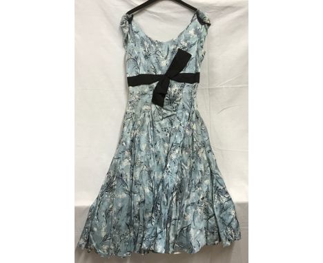 A 1950's ladies dress, handmade, light ble with black bow and fitted underskirt approx. size 26 inch 63cm waist, shoulder to 