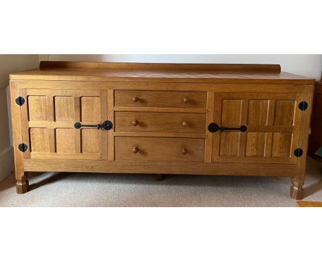 A Robert 'Mouseman' Thompson sideboard with adzed top comprising two cupboards with 3 central drawers, fitting cutlery draw t