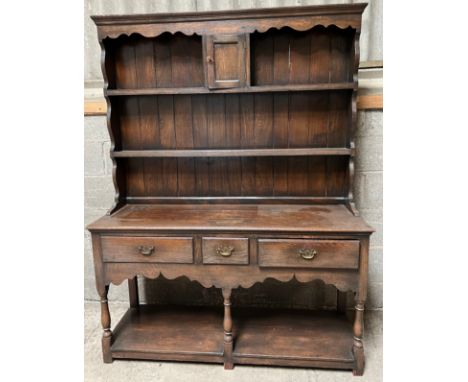 An oak 2 height dresser, 3 drawers to front with raised back comprising 2 shelves and central cupboard. 179 h x 137 w x 42cm 