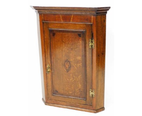 An early 19thC oak and mahogany and marquetry inlaid corner cabinet, the top with four door sections, above a central shelf d