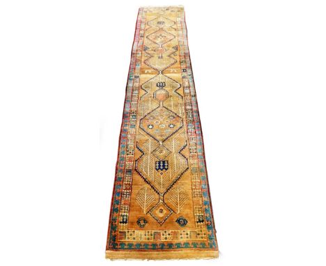 An early 20thC Sarab design carpet runner, with two stylised borders, enclosing a central floral medallion field, with trees,