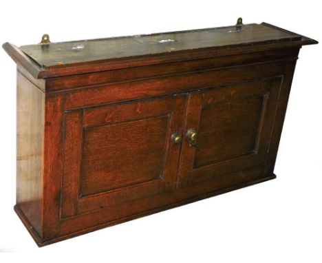 An early 19thC oak wall cabinet, with single shelf and two cupboard doors with brass handles above cornice, 60cm high, 105cm 