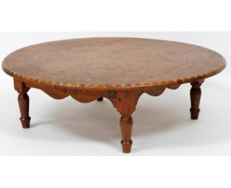 An Eastern inspired pine coffee table, the circular design top with various parquetry and mother of pearl inlay, 86cm diamete