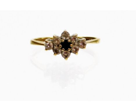 A 9ct gold dress ring, with central floral cluster set with dark blue stone, and white stones, ring size K, 1.8g all in.