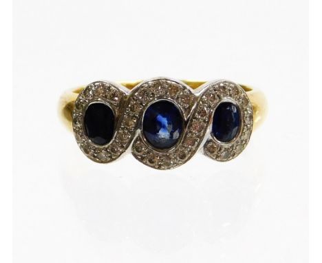 An 18ct gold sapphire and diamond dress ring, the three design section each with oval cut sapphire in rub over setting surrou