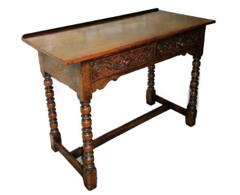 A carved oak hall table, with two frieze drawers, on bobbin turned legs,&nbsp; 76cm high, 106cm wide, 48cm deep.