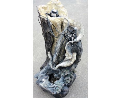 A water feature in the form of a sculptured tree trunk, depicting turrets of trees, with a shaped bowl and power lead, plasti