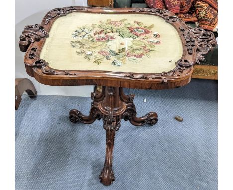 A Victorian rosewood table having a pole screen tapestry top, ornate carved scroll frame and on three cabriole legsLocation: 