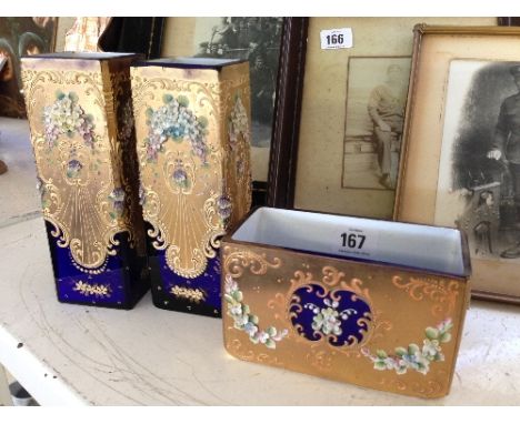 A garniture of gold and enamel overlaid glass vases, decorated with garlands of flowers on gold and blue ground.